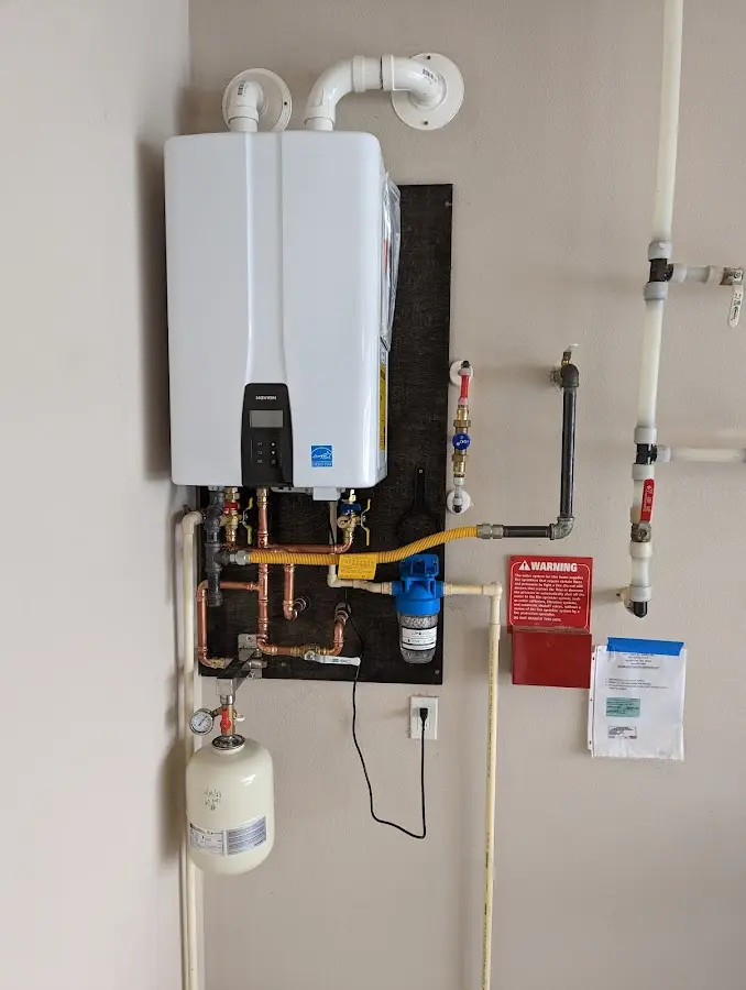 Professional plumber installing copper piping in a Elgin home